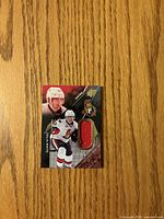 Front of Colin White jersey card showing photo, Senators logo, red fabric swatch