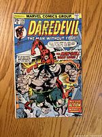 Front cover showing Daredevil #129 with Man-Bull battle scene and 25¢ price