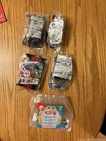 Five sealed McDonald’s Hot Wheels toy cars laid out on table