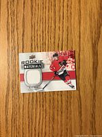 Front of Upper Deck Rookie Materials Kirby Dach jersey card showing white jersey swatch