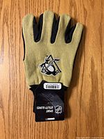 Front view of gloves showing Pittsburgh Penguins logo and hang tag