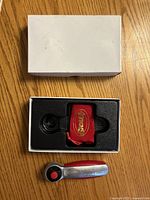 Closed box, opened box showing foam insert with pouch, ratchet displayed