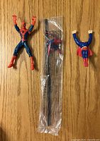 Overview of Spider-Man figure, sealed Spider-Man straw, Superman topper