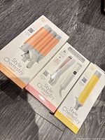 Three boxed Conair Style Chemistry attachments on floor