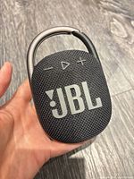 Front view of speaker showing JBL logo, control buttons and carabiner