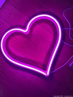 Heart neon light illuminated on floor showing pink glow
