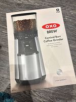 Front of boxed OXO Brew conical burr coffee grinder