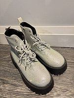 Top view of both silver rhinestone boots showing laces tread and rhinestone surface