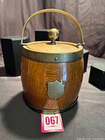 Front view of wooden barrel humidor with brass lid, finial and handle