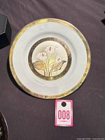 Front view showing lily and butterfly metal engraving and gold rim