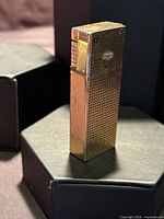 Front view showing gold-tone grid pattern and engraving