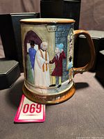 Front view of Royal Doulton Dickens limited edition mug showing relief scene and base