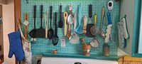 Overall pegboard with utensils, mortar, mitt, shelf