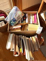 Box of assorted fiction paperbacks and hardcovers plus loose stacked books