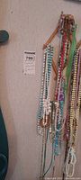 Necklaces hanging on wall, showing variety of bead types and colours