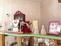 Group of angel figurines, framed print, candlestick and display case on shelf