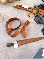 Dagger scabbard with tag 768; leather belt and holster; visible wear and oxidation