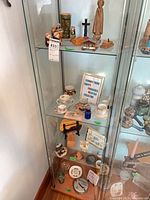 Full cabinet view showing majority of small collectibles on three shelves