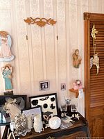 overall view of plaques, framed pieces, figurines, glasses and shelf