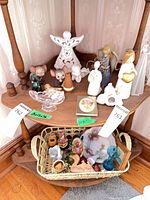 Overall view of shelf with figurines, glass dove dish and angels