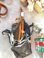 Backpack holding two wooden scabbards and rope