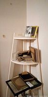 Tower shelf holding multiple picture frames on three tiers