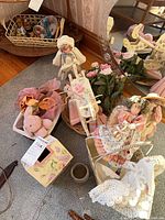 Group of items on floor including rocking horse, dolls, planter, box, faux flowers, teddy bear, mirror
