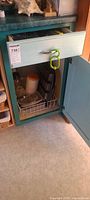 Cabinet view showing muffin pan and storage containers in wire basket