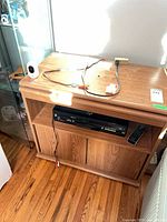 Overall view of TV stand with combo unit, cables and remote
