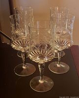 Five etched crystal goblets grouped on tabletop
