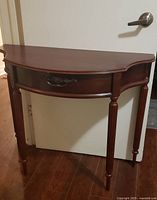 Front view of demilune side table showing drawer and legs