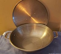 open stainless steel wok showing interior and lid