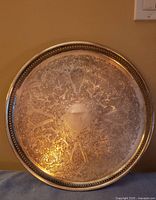 Front of large round engraved tray showing detailed floral pattern