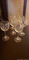 six small etched wine glasses grouped on table