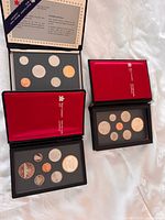 All four coin sets displayed, two open to show coin arrangements