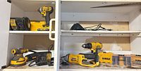 Overview of cabinet shelves with DeWalt cordless tools, chargers and bit cases