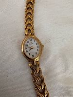 Full view of Bulova gold-tone watch showing dial and bracelet