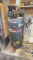 Full view of Sanborn vertical air compressor showing pump, motor, and tank