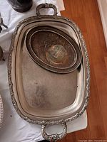 Rectangular tray with oval dish inside, showing ornate border and etched surface