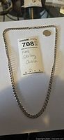 Full view of sterling silver curb chain with tag
