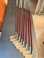 Eight Affinity golf irons laid out showing full length and grips