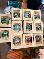 Stack of eleven boxed Campus Originals Billerica ornaments