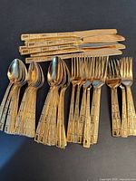 Full view of set showing knives, two spoon sizes, forks