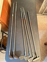 Six junior clubs laid out, showing full length and grip condition