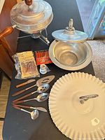 Group shot of all items including fondue pot, casserole holder, platter, utensils, cheese forks, toothpick holder