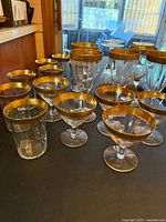 Mixed Tiffin Franciscan gold-rim stemware and tumblers on table