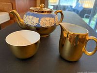 Teapot front, sugar bowl and creamer grouped