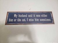 Front view of the humorous navy blue metal sign with text