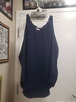 Front view of navy sleeveless blouse on hanger