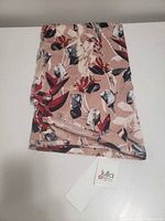 Full view of folded Lulla floral scarf showing pattern and attached brand tag